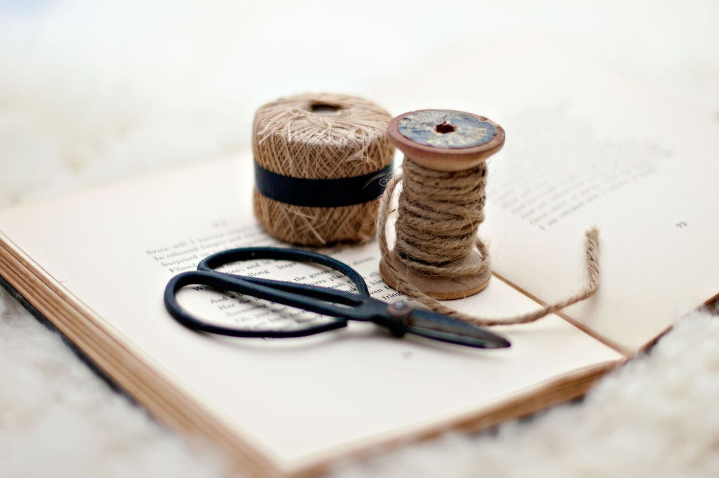 Close-up of a pair of scissors and twine on a vintage book