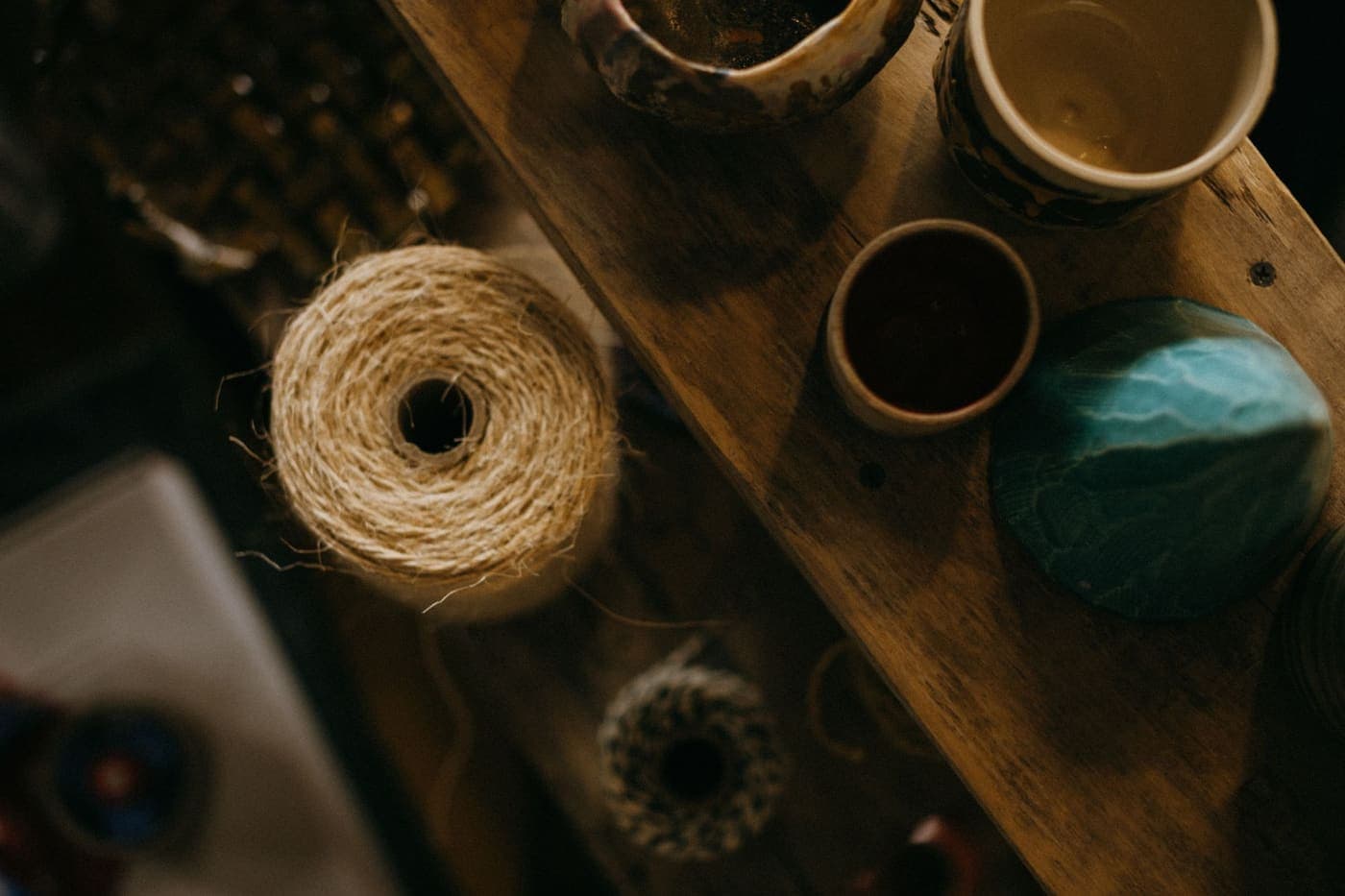 An overhead view of a roll of thread beside cups