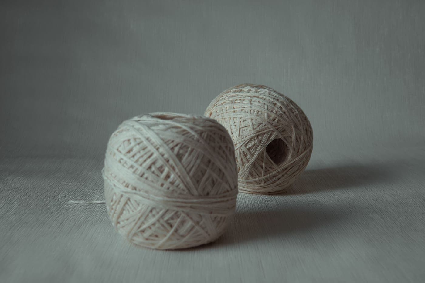 Natural undyed alpaca yarn coiled on a plain surface