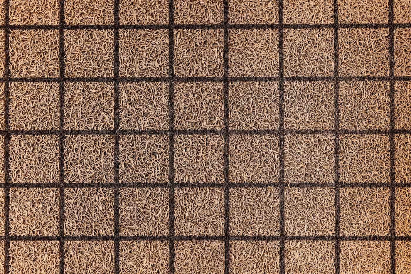 A knitted swatch pinned out on a gridded blocking mat to dry