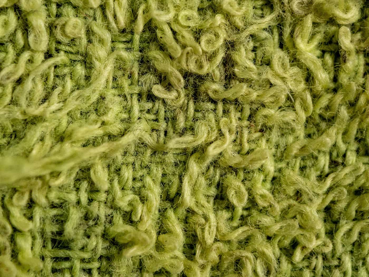Close view of a knitted fabric surface showing texture and fiber ends