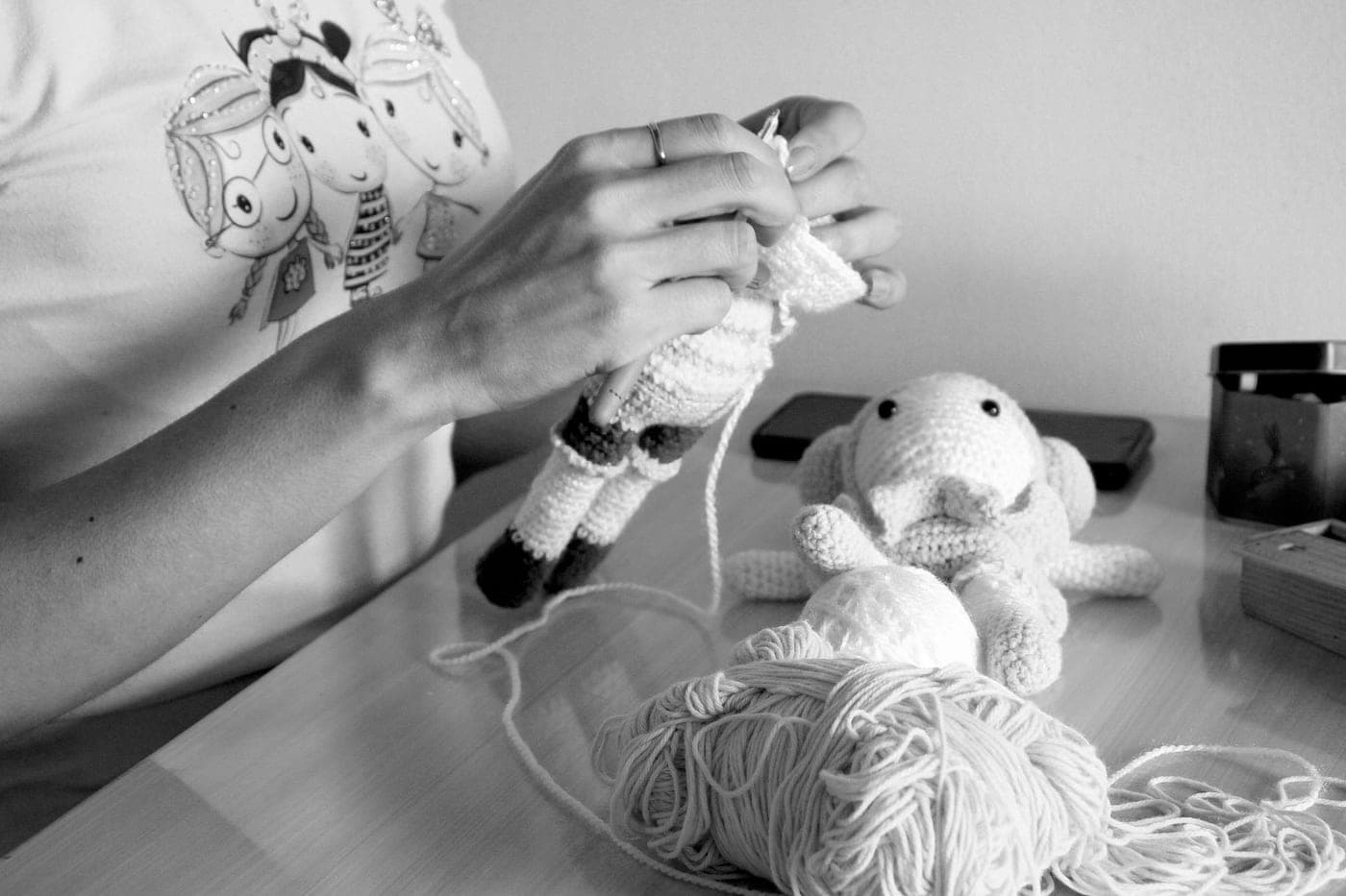 An adult craft project in progress on a table with yarn and tools