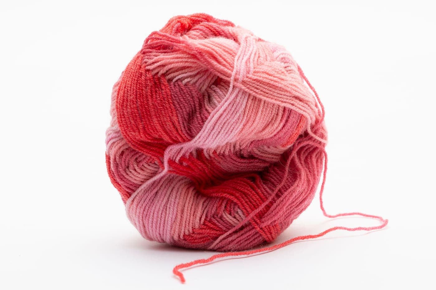 A ball of red and pink yarn on a white background
