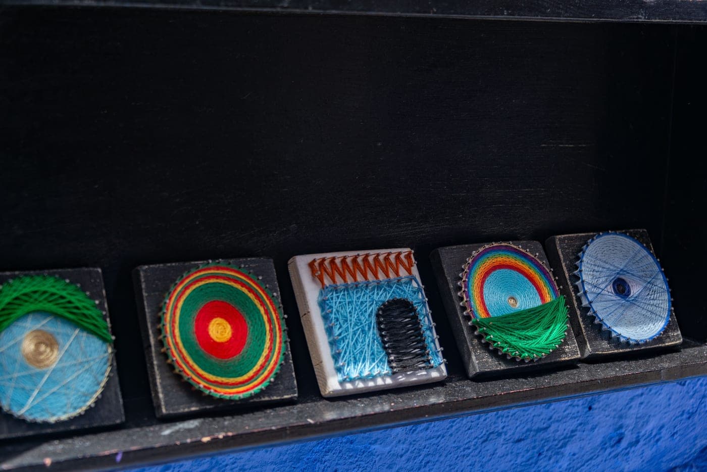 A collection of finished yarn craft pieces in different techniques