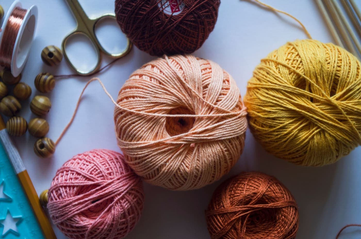 Colorful balls of yarn with crafting tools arranged on a work surface