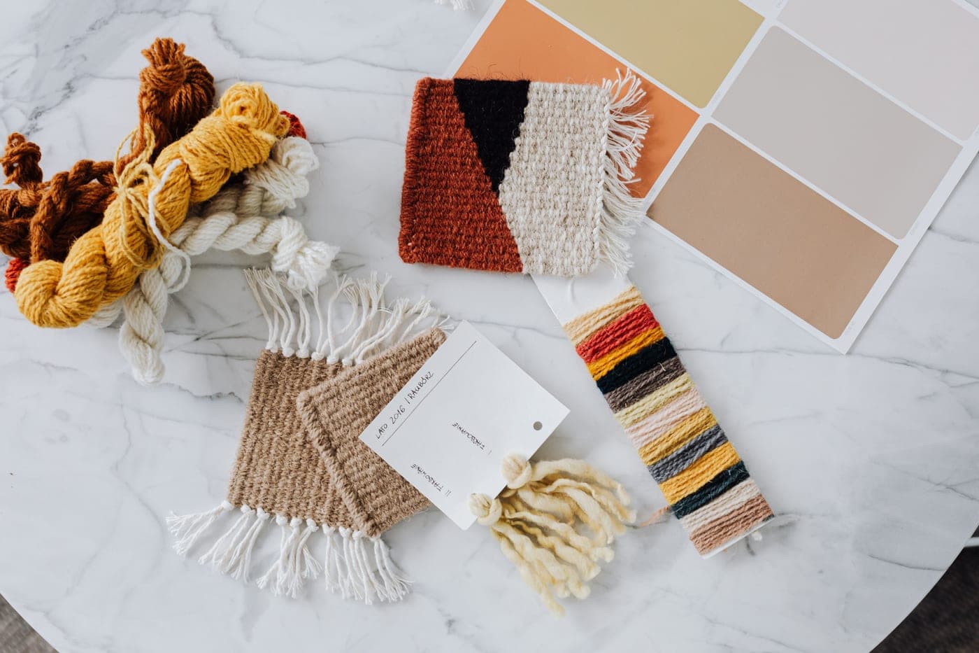 Several yarn craft pieces arranged together - knitting, crochet and weaving samples