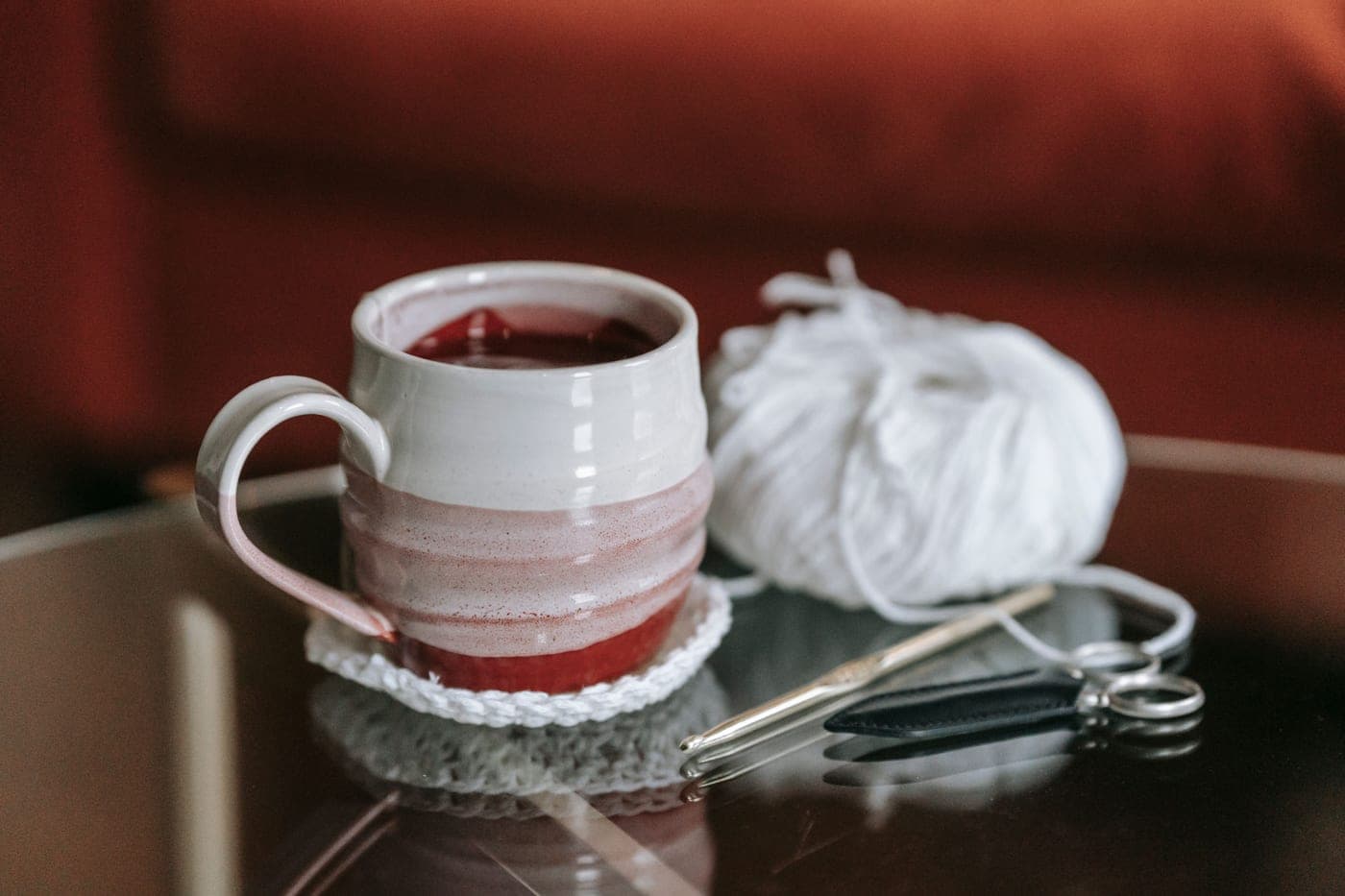 A crochet hook with a thick cushioned handle resting on a work surface