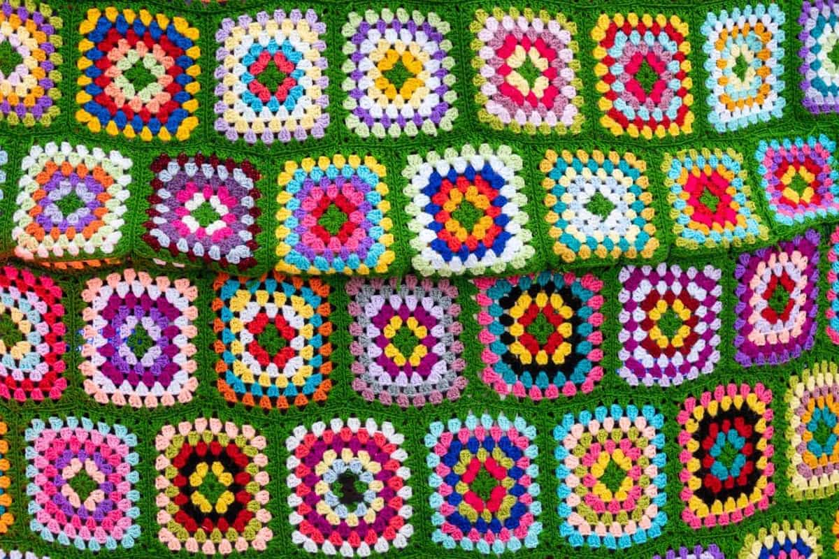 A vibrant crochet afghan with geometric patterns photographed outdoors