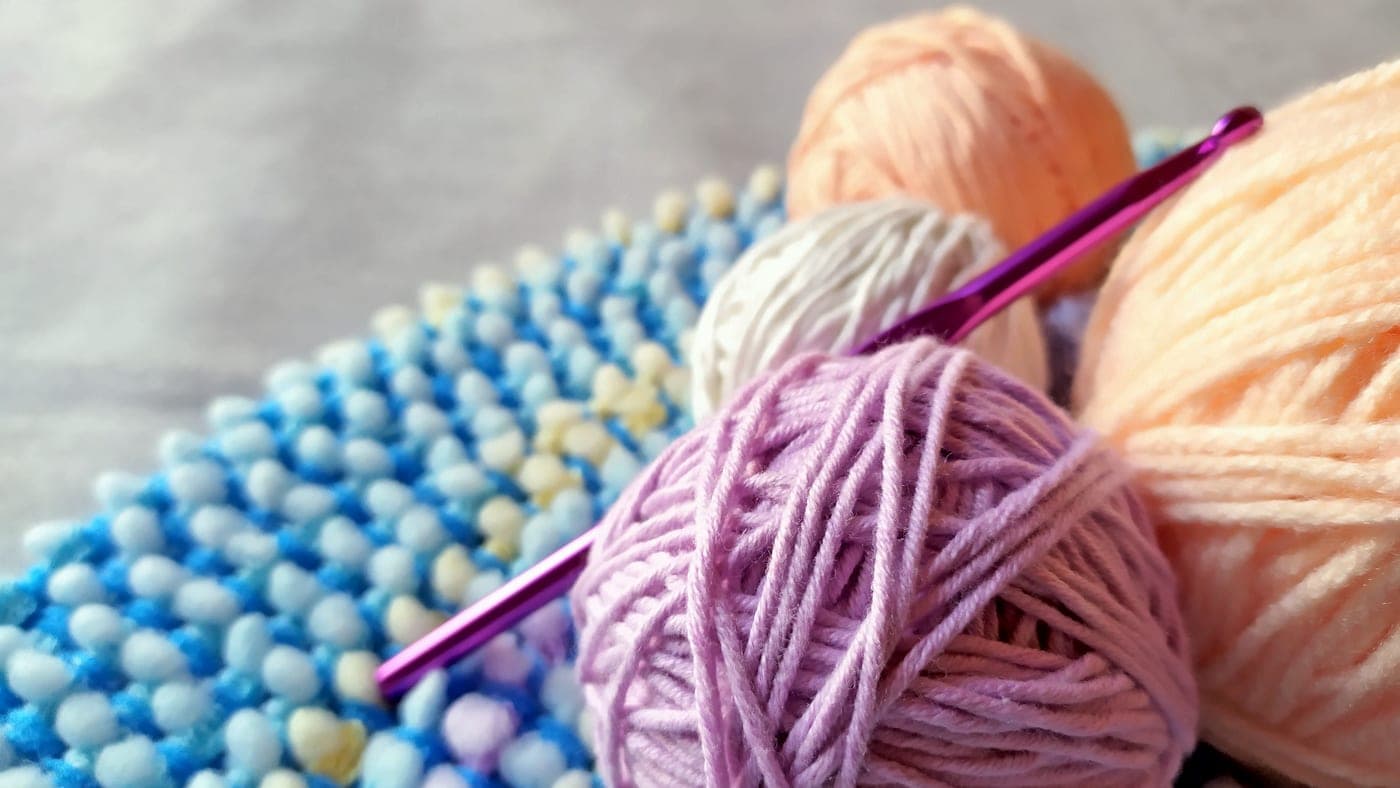 A knitting starter set with needles, a ball of yarn and a pattern card