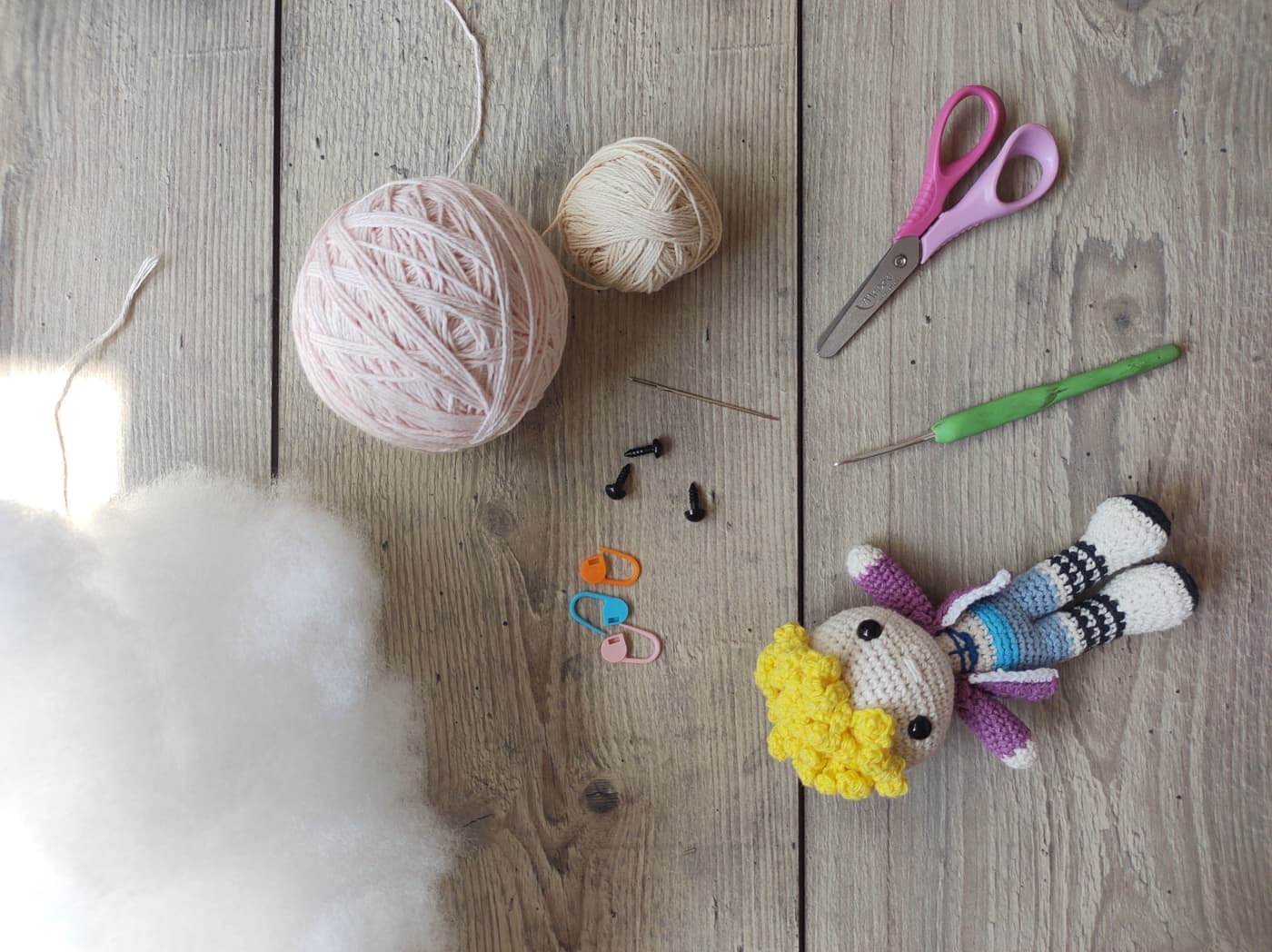 The contents of a starter kit laid out - needles, hook, yarn, markers and scissors