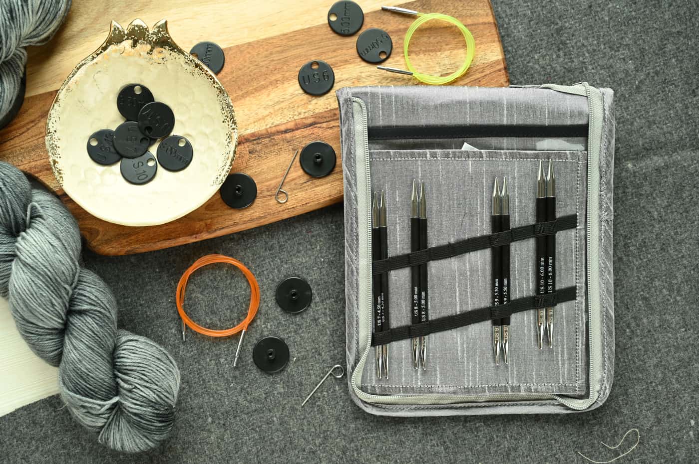 Circular and straight knitting needles arranged on a plain work surface