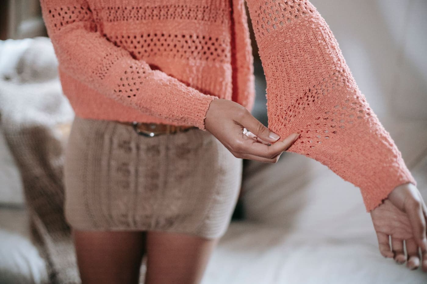 A person wearing a knitted sweater and skirt, showing the fabric