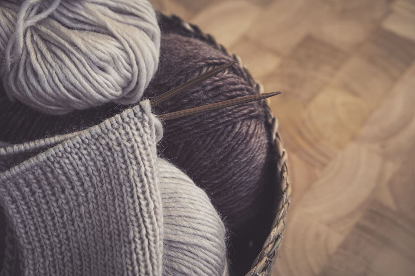 A knitting project with woolen yarn resting in a basket