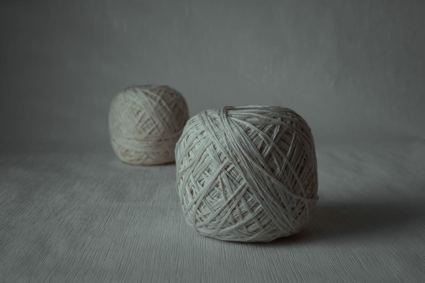 Skeins of yarn in several thicknesses laid side by side on a plain surface