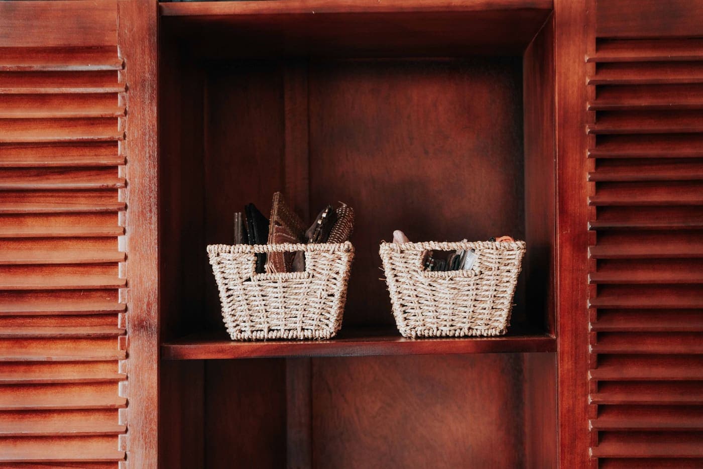 Two woven storage baskets on a wooden shelf