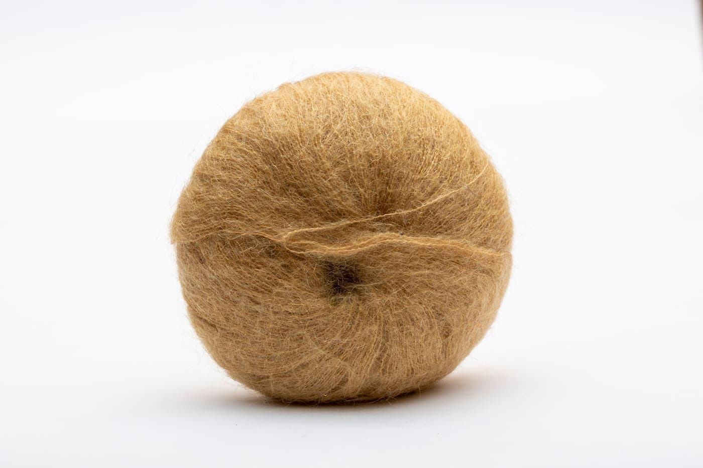 A fluffy ball of brown wool yarn on a white background