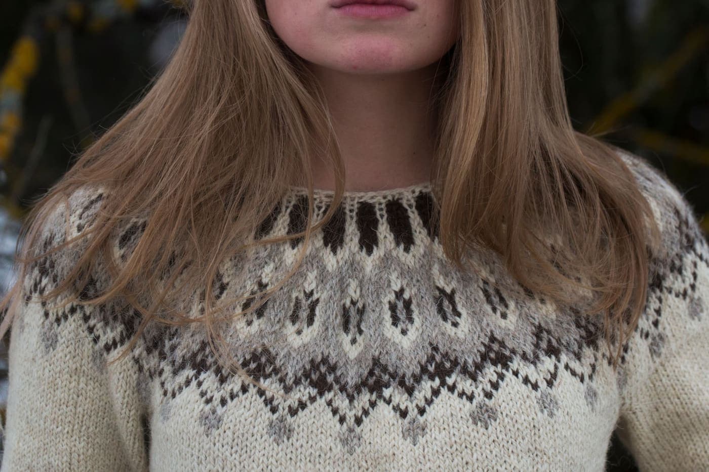 Close-up of a knitted sweater with a Nordic colorwork design worn outdoors