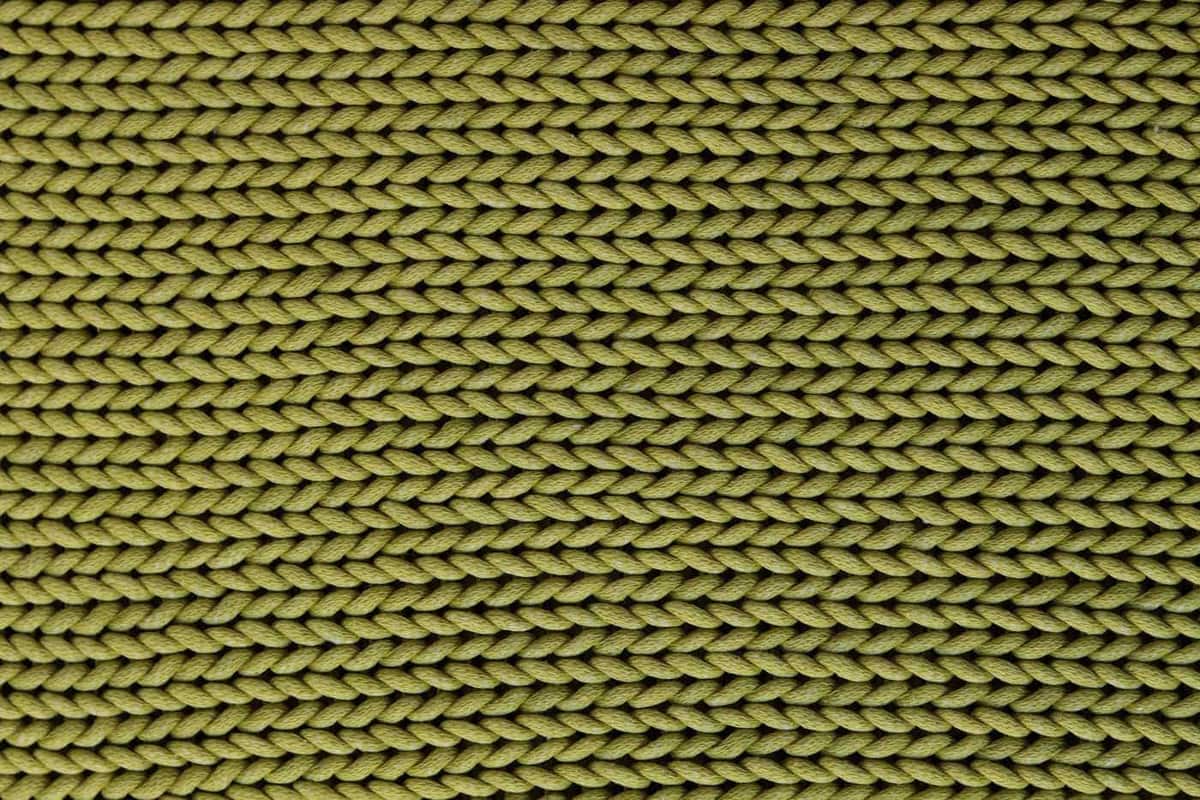 Close-up of a green knitted fabric showing its texture